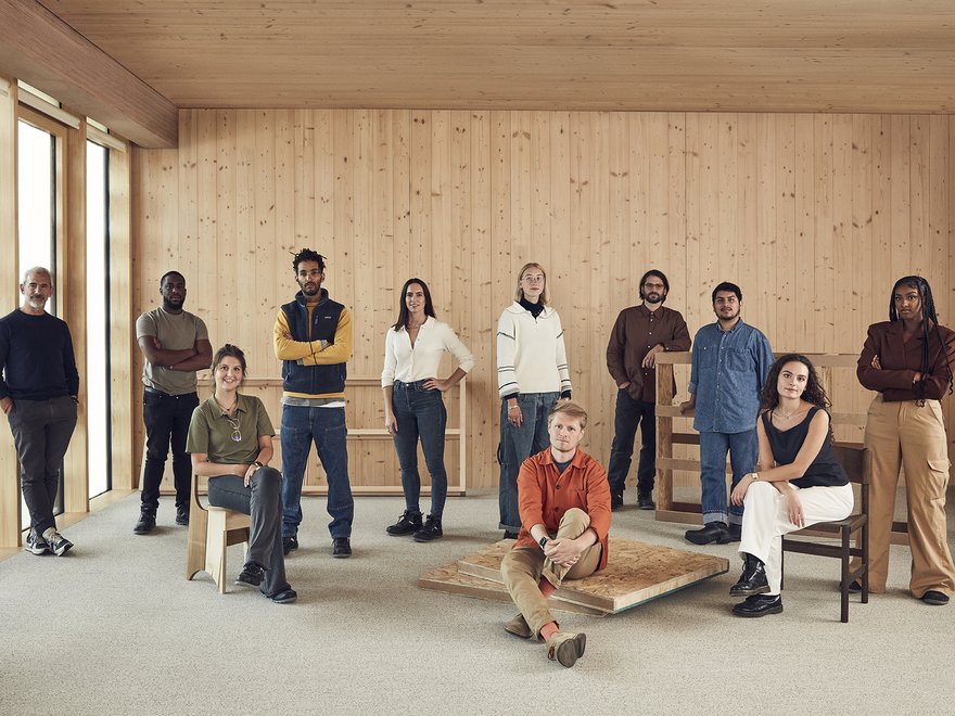 a group of people stand in an empty room looking towards the camera