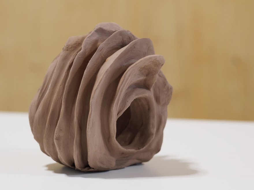 swirling sculpture made from terracotta clay
