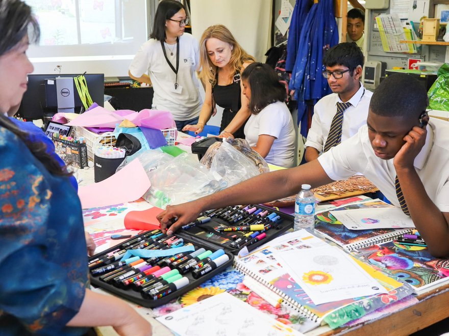 A classroom of teenage kids work on a creative project