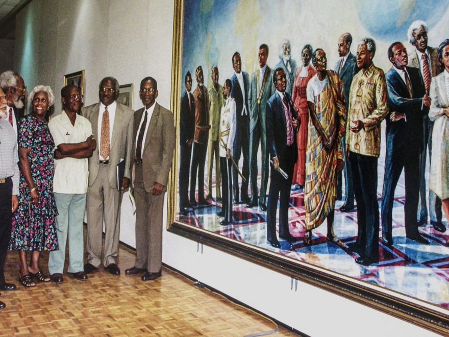 A group of people stand next to a large-scale oil painting