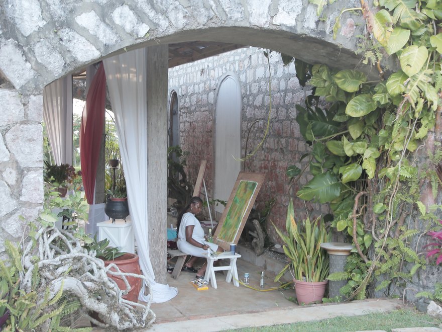 A woman paints outside on a terrace