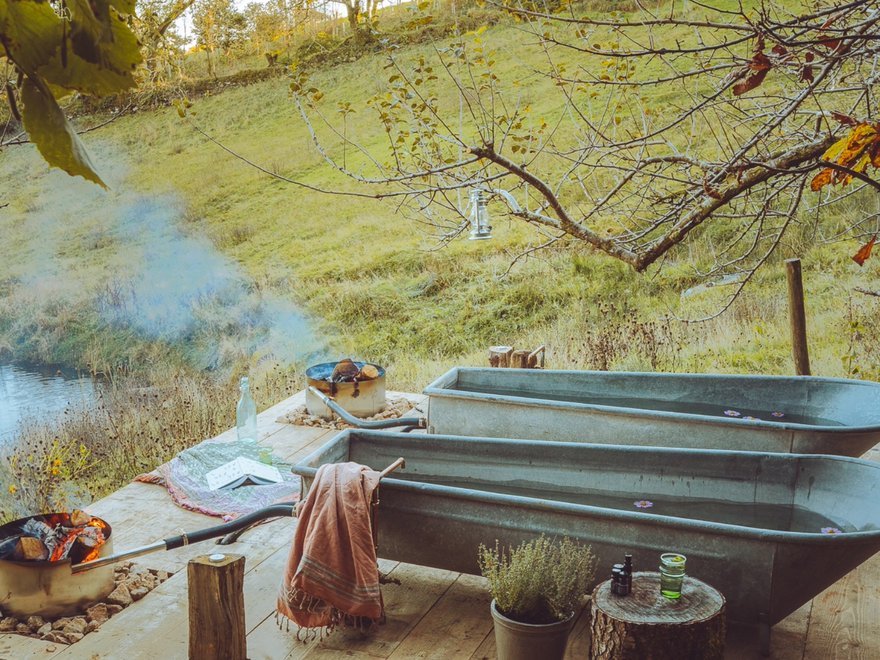 A lake in the countryside with tin baths on a porch