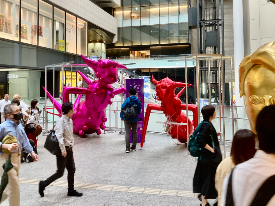 giant inflatable insect installation in a busy train station
