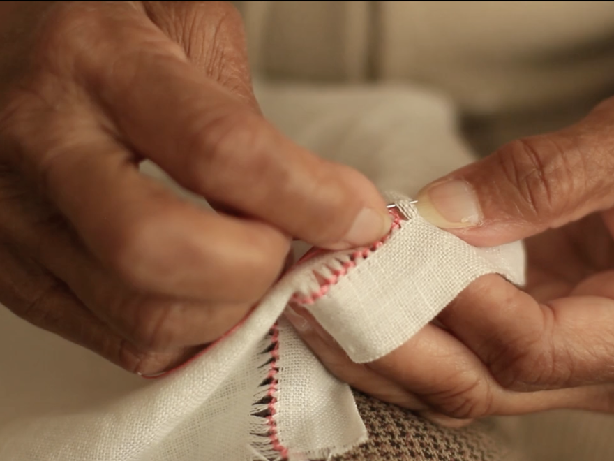 close up of elderly womans hands sewing
